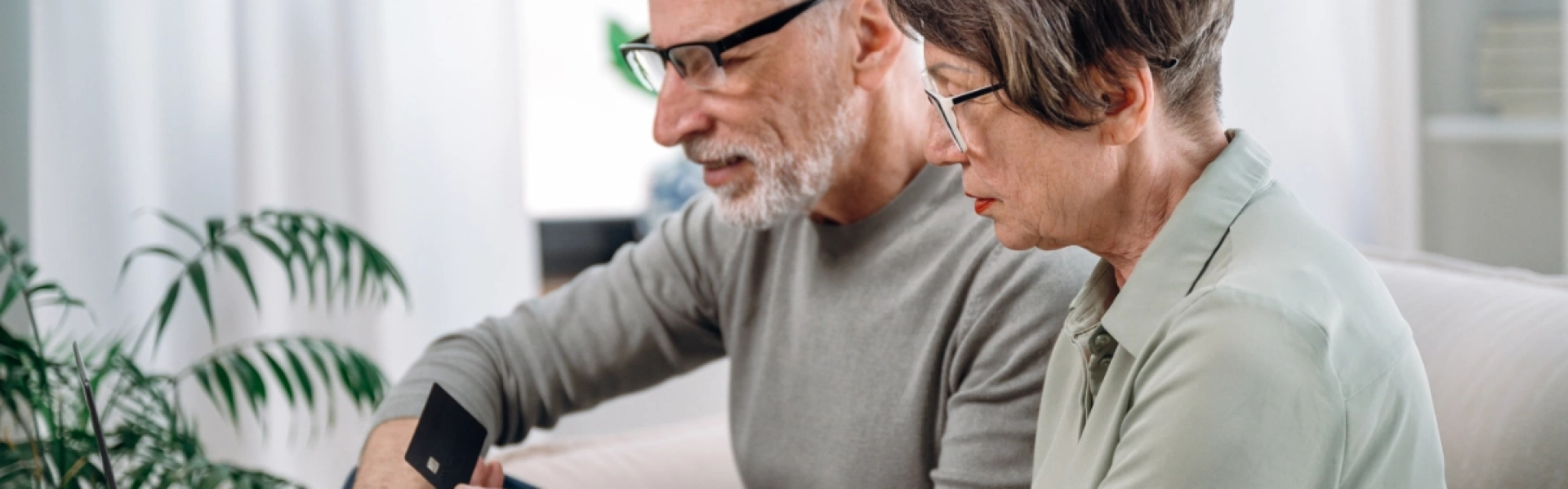 Ein älteres Ehepaar, das Medikamente online mit der Bankkarte kauft.